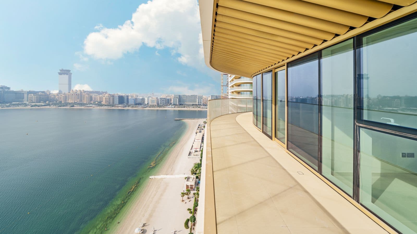 Balcony of a high-rise overlooking a sandy beach and coastal skyline