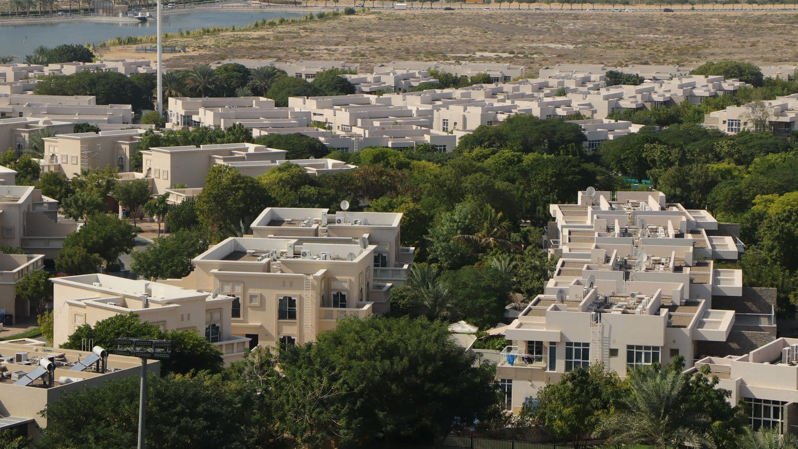 Aerial view of a low-rise villa and townhouse community among mature trees